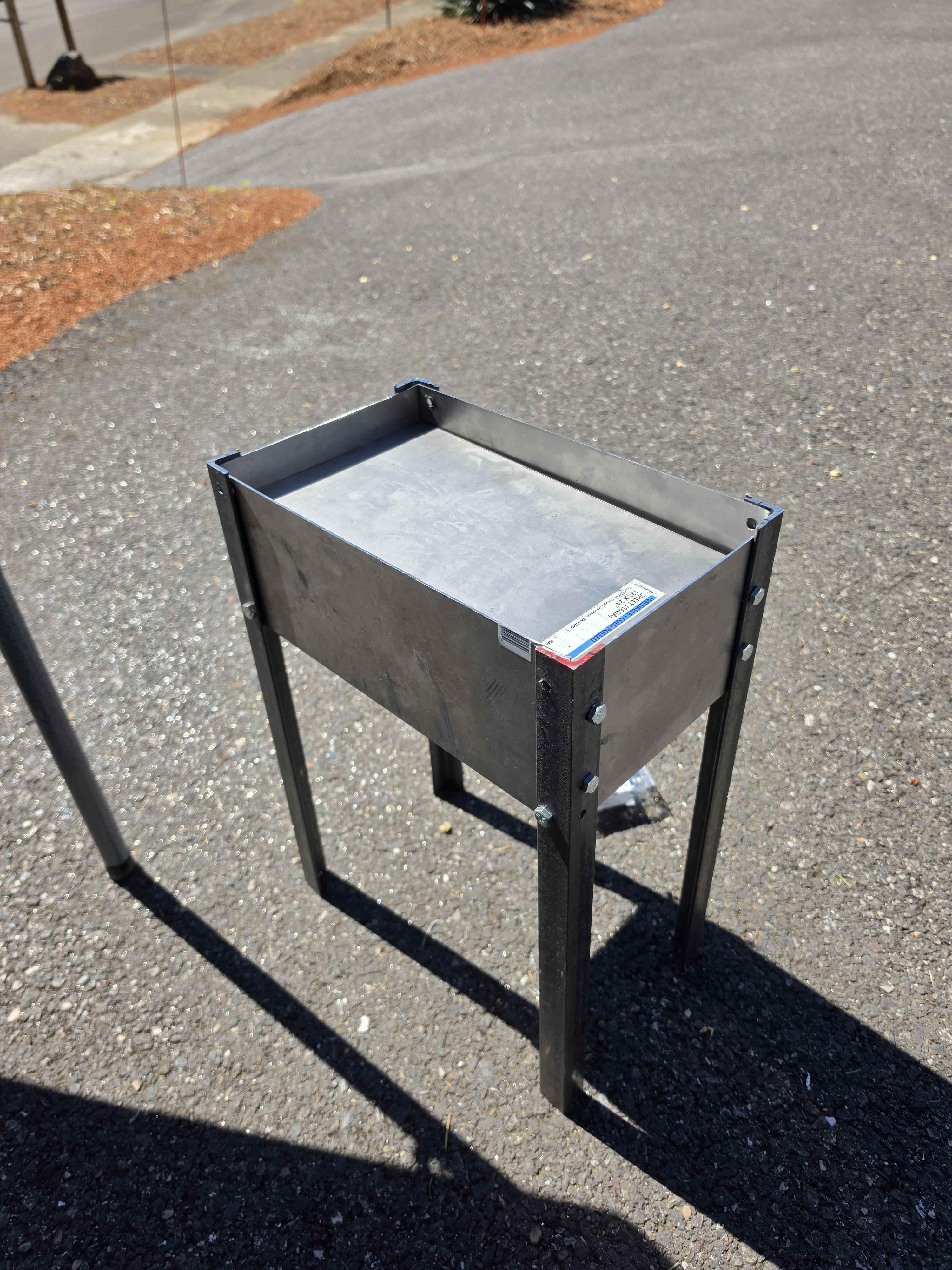 The assembled flat-pack firepit standing on pavement