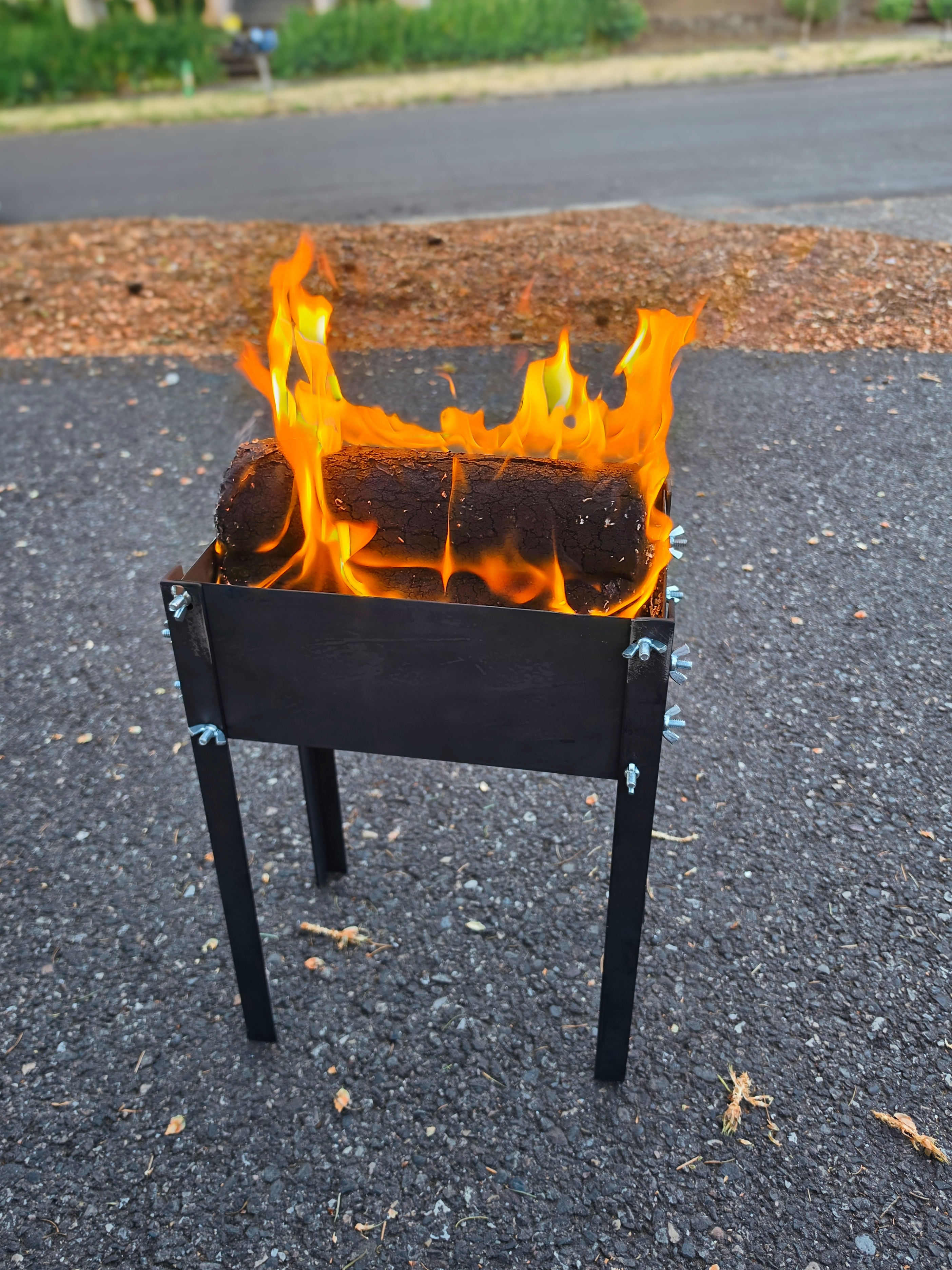 The flat-pack firepit burning outdoors